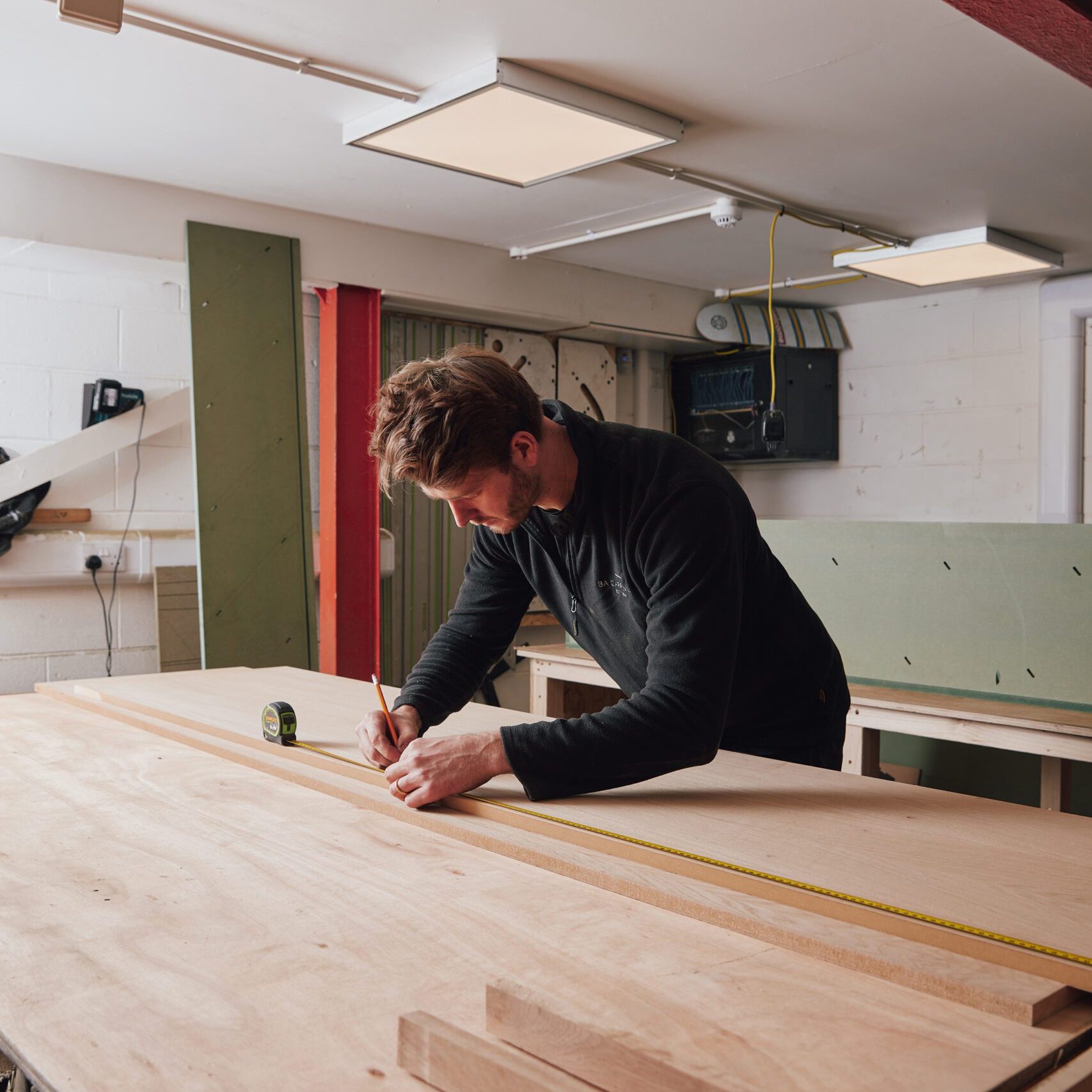 Carpenter Ben making detailed measurements before making a custom cut